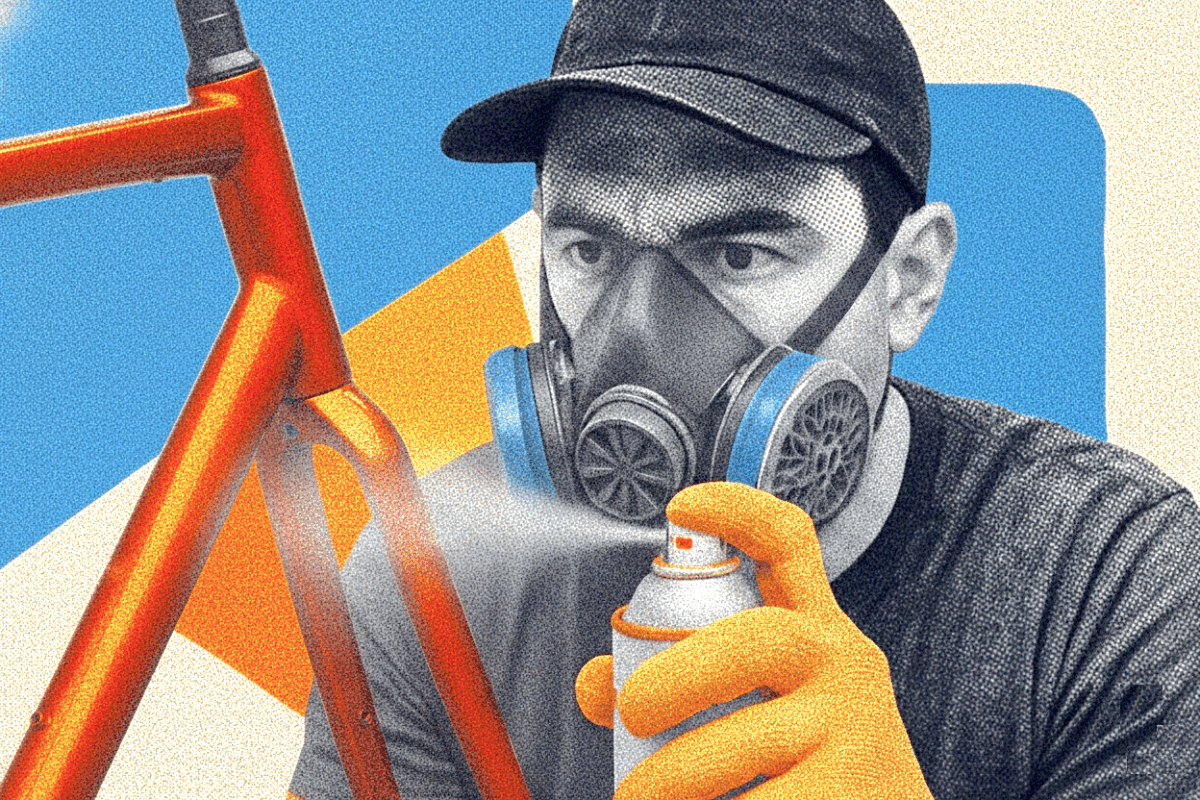 Image of a man spray painting a bike frame.